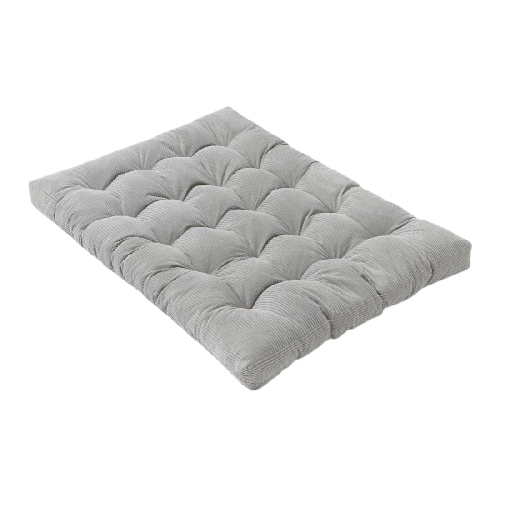 Coussin de sol en velours côtelé gris avec design matelassé.
